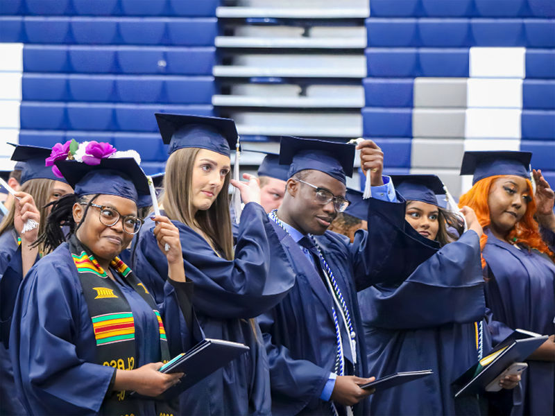 People in graduation caps moving their tassels